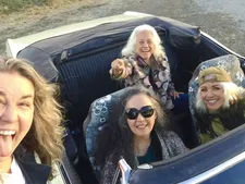 Bobbi Jo Hart, Jean Millington and June Millington with Brie Howard Darling driving the convertible