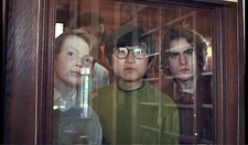 Angus (Dominic Sessa) looking over the shoulders of Alex (Ian Dolley), Ye-Joon (Jim Kaplan) and Kountze (Brady Hepner)