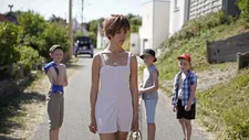 Line (Lyna Khoudri) passing three little boys